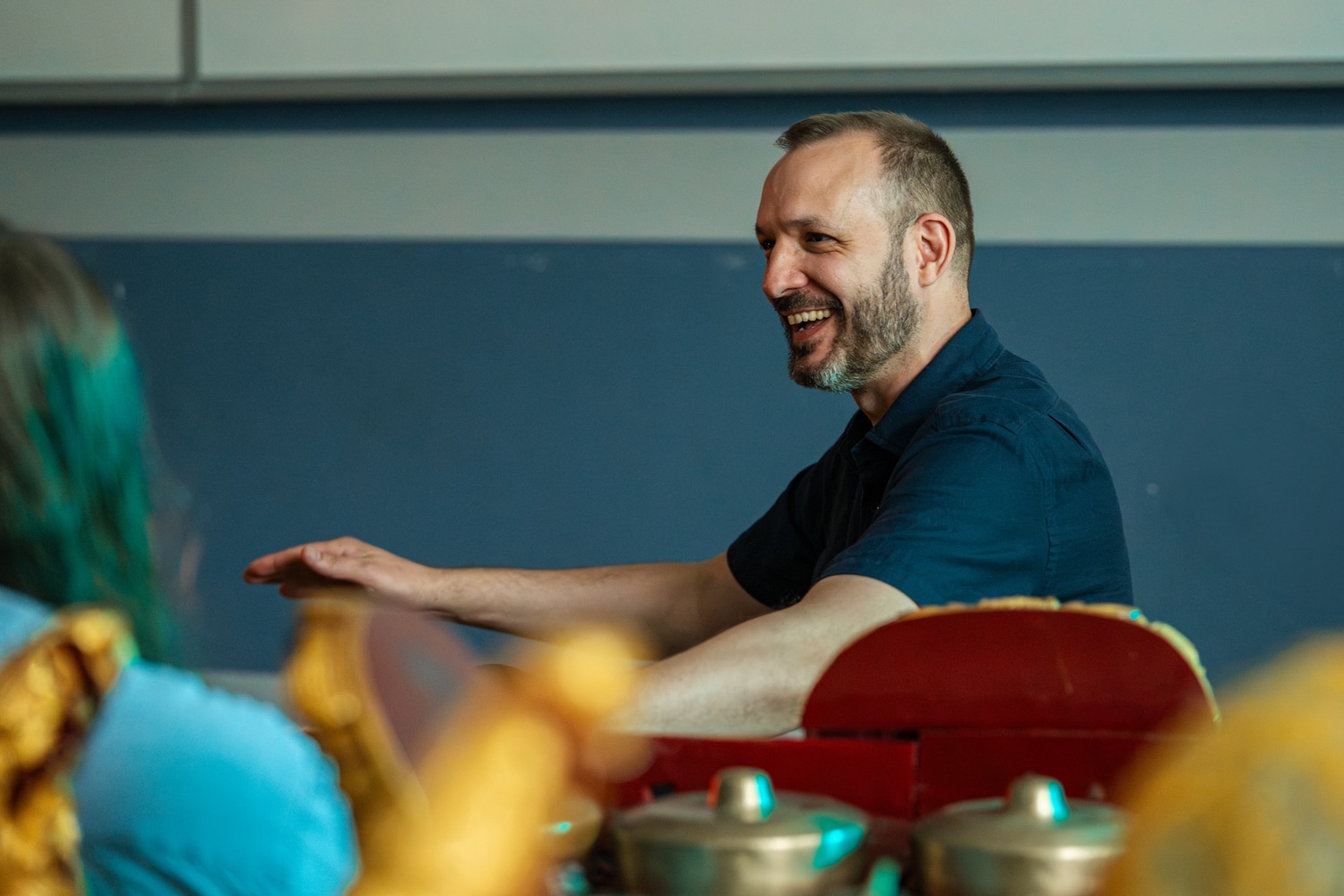 Male professor smiling while teaching gamelan class