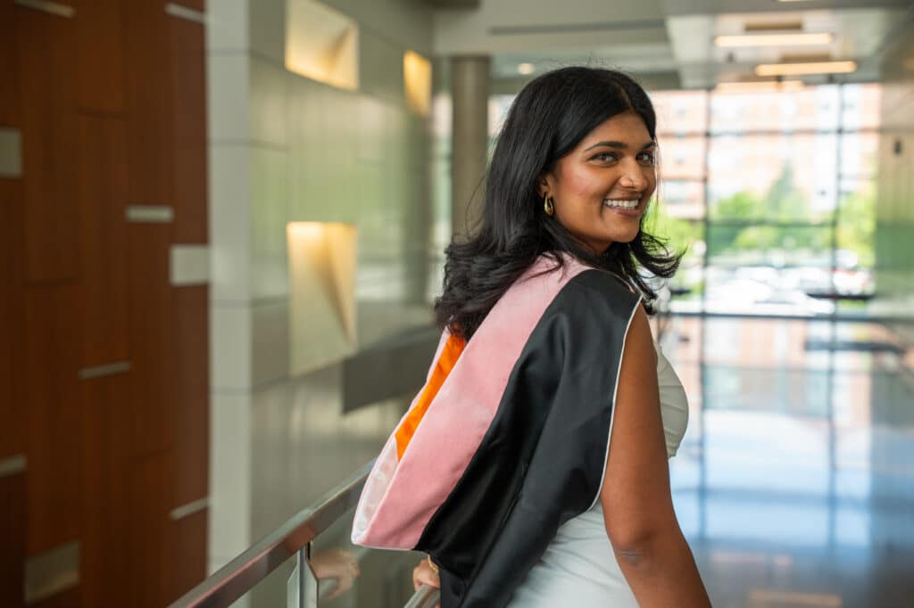 Female student posing with graduate hood