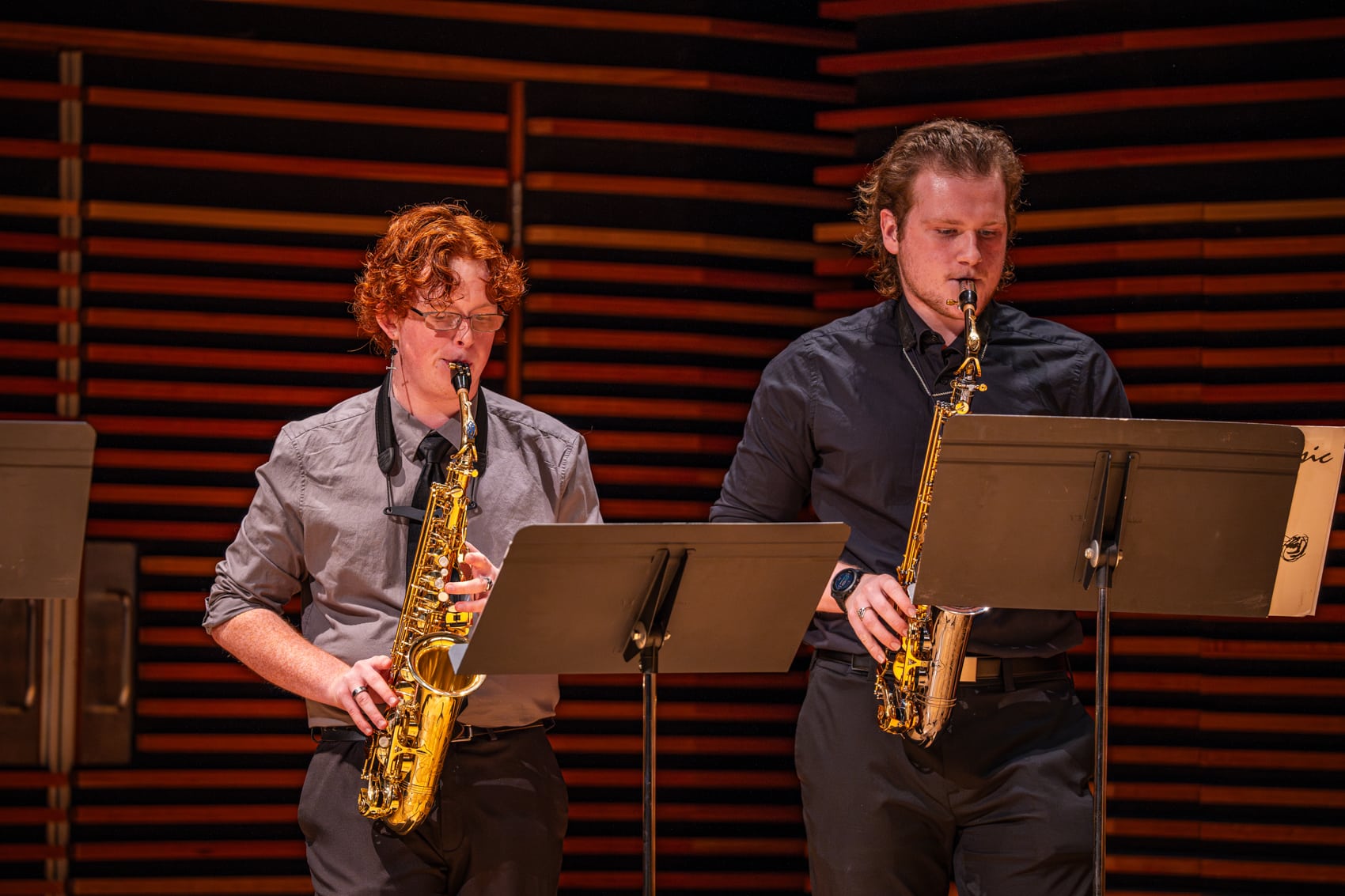 Two men on stage playing the saxophone