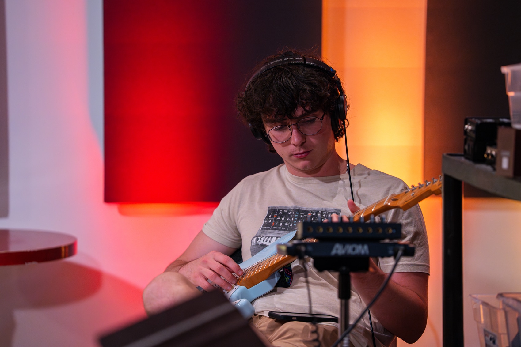 Student playing guitar in recording studio