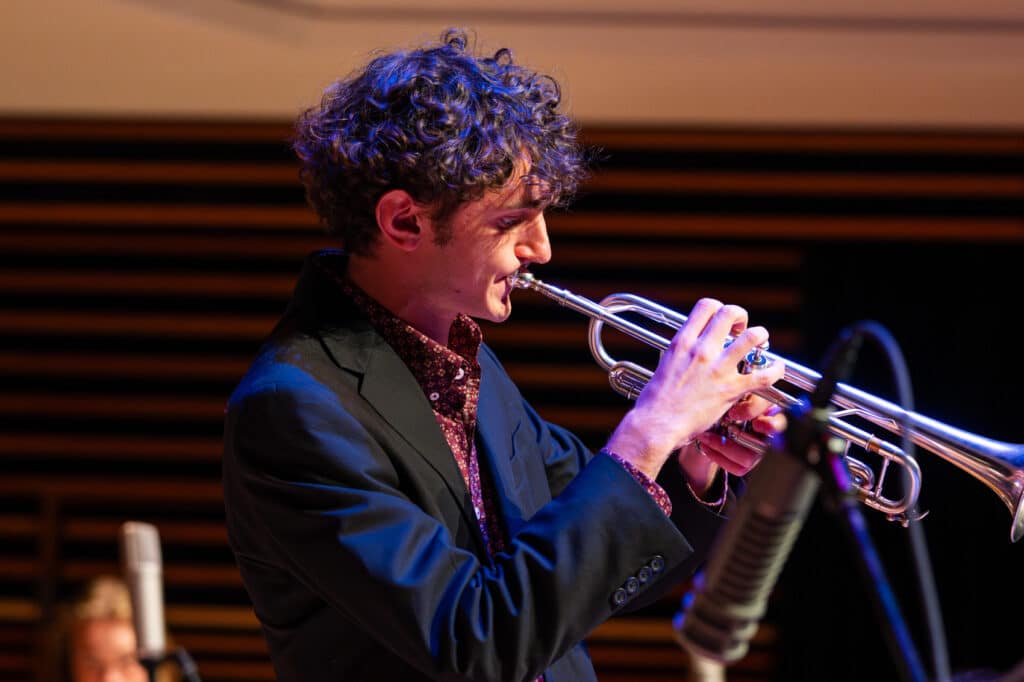 Photo of student playing trumpet during big band concert.