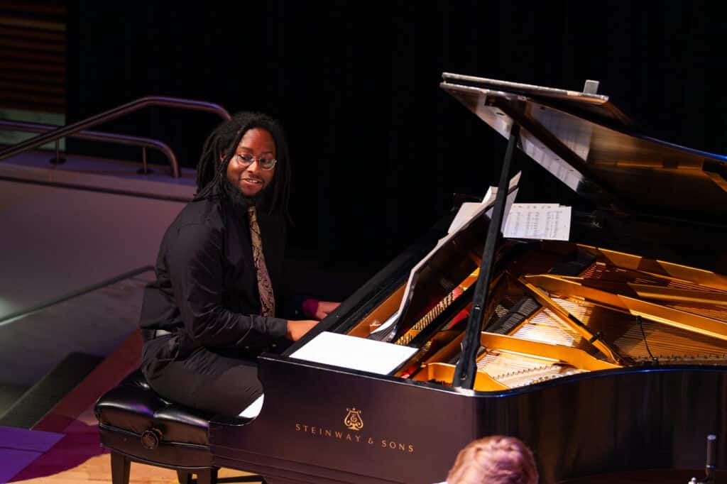 Man playing the piano and smiling.