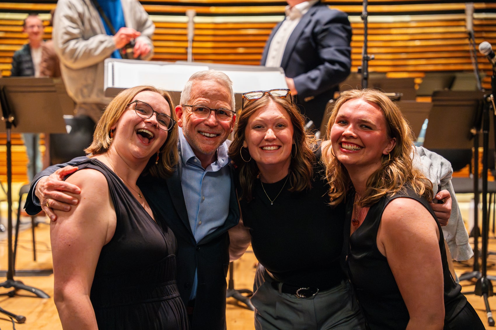 Dean Pappas poses with students in front of stage