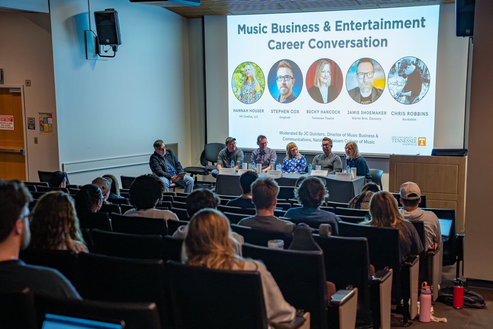 Group of professionals in front of a PPT labeled "Music Business & Entertainment Career Conversation" with students listening