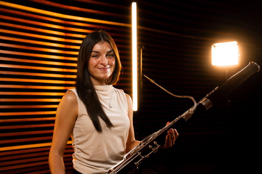 Girl holding a bassoon on stage.