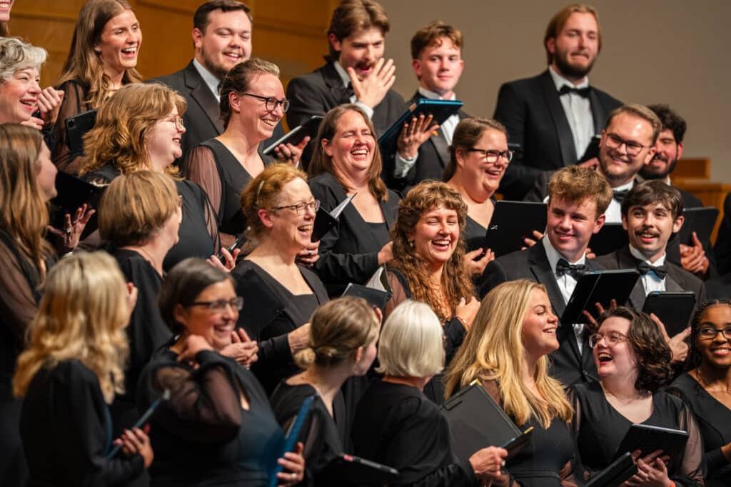 Choir singers on stage laughing and smiling