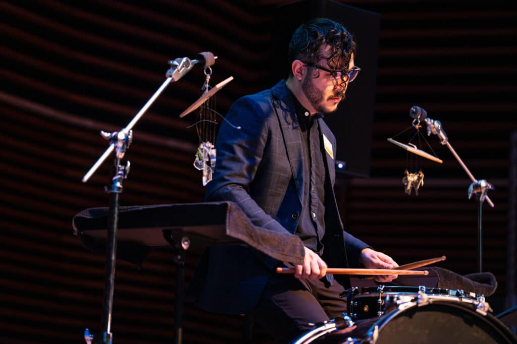 Man playing the drums on a dark stage