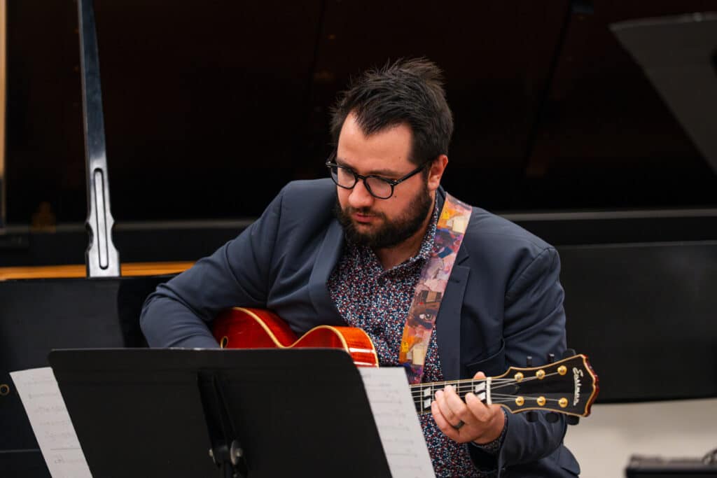 Male professor playing guitar