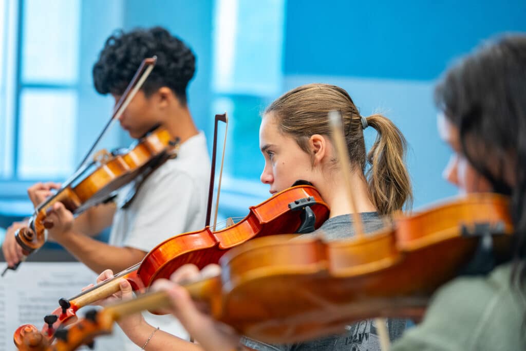 Female string student playing instrument.