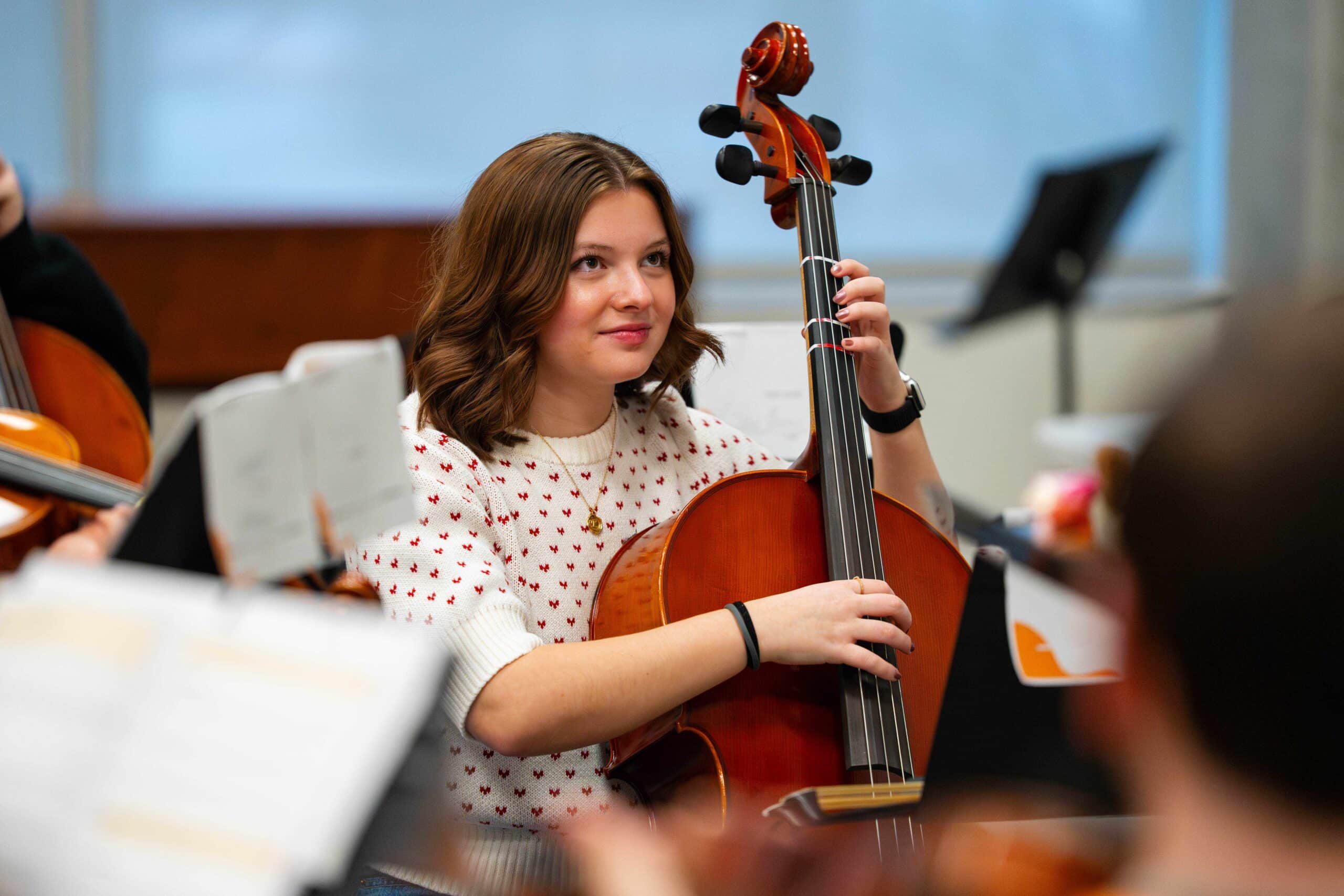 Student smiling and holding Cello in playing position in Professor Ammerman's class.