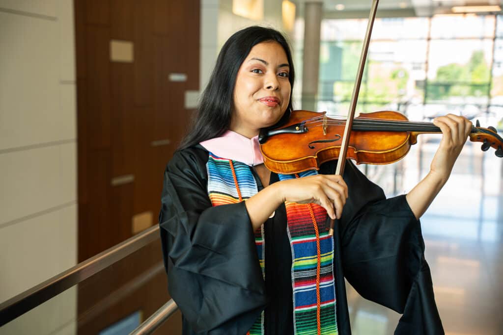 Female in regalia holding violin